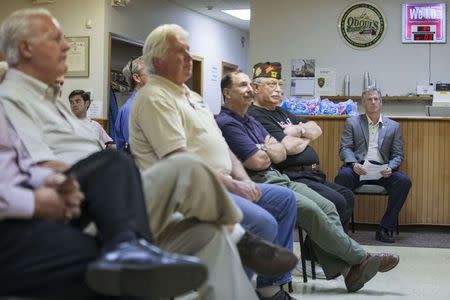 Scott Brown, a Republican candidate for the U.S. Senate, listens as he is introduced at a town hall campaign stop at a VFW post in Hudson, New Hampshire September 3, 2014. REUTERS/Brian Snyder