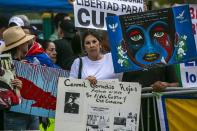 Demonstrators hold signs and shout slogans to protest at the baseball game between the United States and Cuba in front of LoanDepot Park prior to the baseball game, in Miami, Sunday, March 19, 2023. (Jose A. Iglesias/Miami Herald via AP)