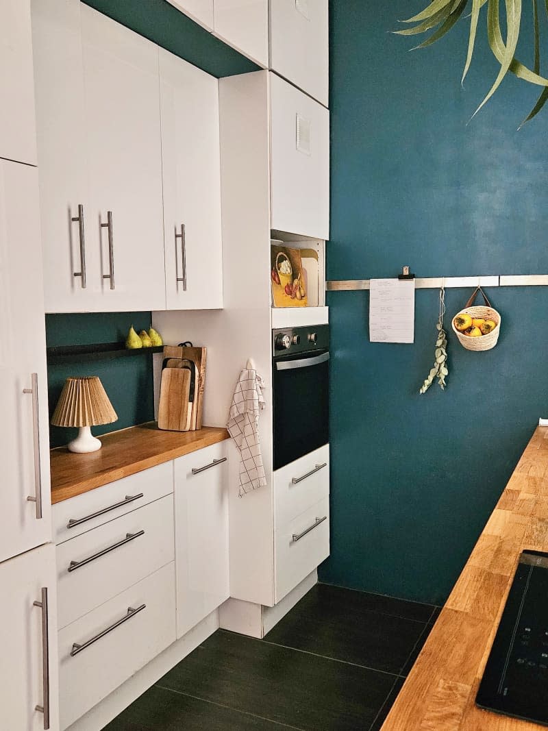 A kitchen with white cabinets and blue accent walls.