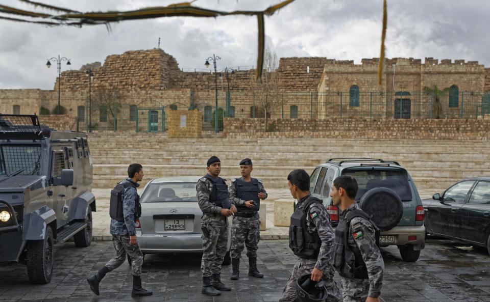 Jordanian security forces and their armored vehicles stand guard outside Karak Castle in the central town of Karak, about 140 kilometers (87 miles) south of the capital Amman, in Jordan Monday, Dec. 19, 2016. Gunmen assaulted Jordanian police in a series of attacks Sunday, including at the Karak Crusader castle popular with tourists, officials said. (AP Photo/Ben Curtis)