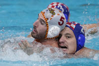 Spain's Miguel de Toro Dominguez (5) and Croatia's Marko Macan (2) battle for position during a preliminary round men's water polo match at the 2020 Summer Olympics, Monday, Aug. 2, 2021, in Tokyo, Japan. (AP Photo/Mark Humphrey)