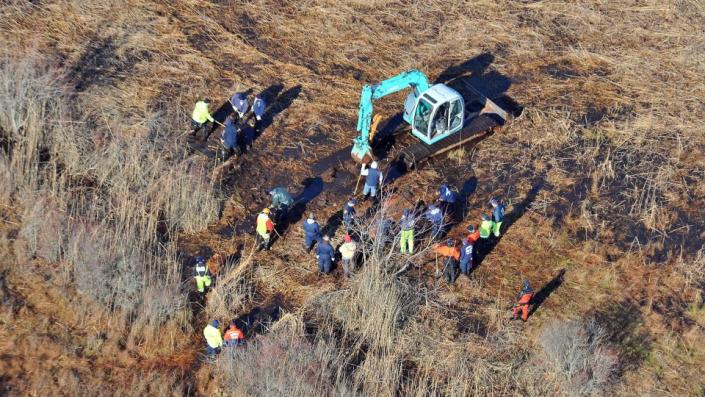 In this Dec. 8, 2011 photo, investigators use a backhoe to dig while searching for Shannan Gilbert's body in different sectors of a marsh area just east of Oak Beach, New York.  - Kevin P Coughlin/AP/File