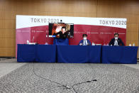 Olympic Games Executive Director of IOC Christophe Dubi (on screen) waves as chief of main operation centre of Tokyo 2020 Hidemasa Nakamura, center, and The Tokyo Organizing Committee of the Olympic and Paralympic Games spokespersons and Masa Takaya, right, are seen at the end of an online press briefing for the presentation of the version three of Tokyo 2020 Playbook in Tokyo, Tuesday, June 15, 2021. (Behrouz Mehri/Pool Photo via AP)