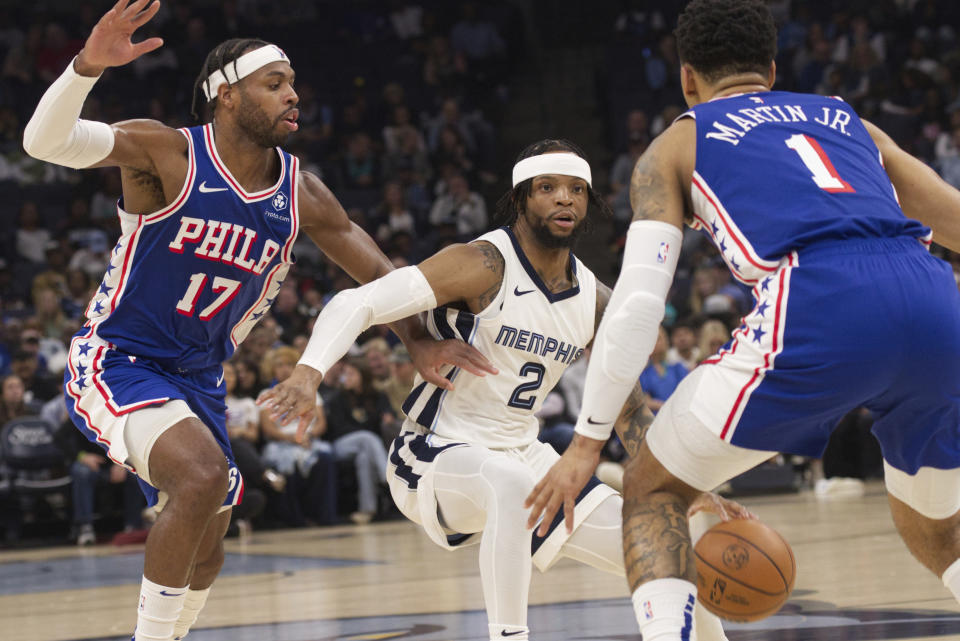 Memphis Grizzlies guard Xavier Simpson (2) gets caught between the defense of Philadelphia 76ers guard Buddy Heild (17) and forward KJ Martin (1) during the first half of an NBA basketball game Saturday, April 6, 2024, in Memphis, Tenn. (AP Photo/Nikki Boertman)