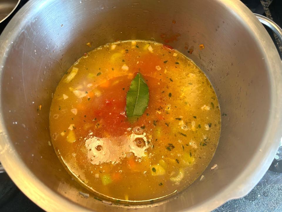 Adding bay leaf to broth for Ina Garten's winter minestrone soup