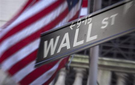 A Wall Street sign is pictured outside the New York Stock Exchange in New York, October 28, 2013. REUTERS/Carlo Allegri