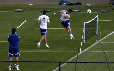 Argentina's national soccer team player Lionel Messi (R) heads the ball next to teammate Fernando Gago during a training session ahead of their 2014 World Cup final match against Germany in Vespasiano, July 11, 2014. REUTERS/Marcos Brindicci