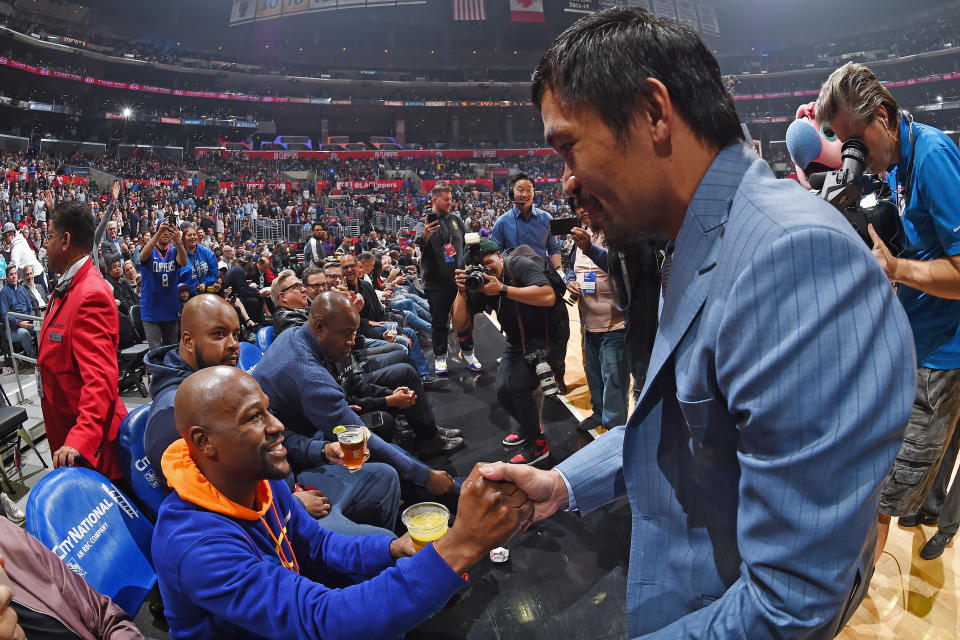 Floyd Mayweather and Manny Pacquiao greet each other during the game between the Charlotte Hornets and Los Angeles Clippers on Jan. 8, 2019 at Staples Center in Los Angeles. (Andrew D. Bernstein/NBAE via Getty Images)