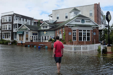 A man walks through a flooded street after Hurricane Arthur passed through in Manteo, North Carolina July 4, 2014. REUTERS/Chris Keane