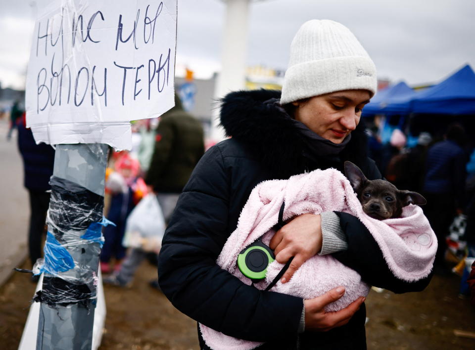 A woman fleeing Russian invasion of Ukraine holds a dog at a temporary camp in Przemysl, Poland, February 28, 2022. REUTERS/Yara Nardi