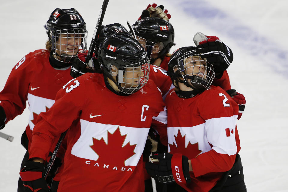 Meghan Agosta-Marciano of Canada (2) is congratulated by Caroline Ouellette (13) after scoring a goal against Finland during the third period of the 2014 Winter Olympics women's ice hockey game at Shayba Arena, Monday, Feb. 10, 2014, in Sochi, Russia. (AP Photo/Petr David Josek)