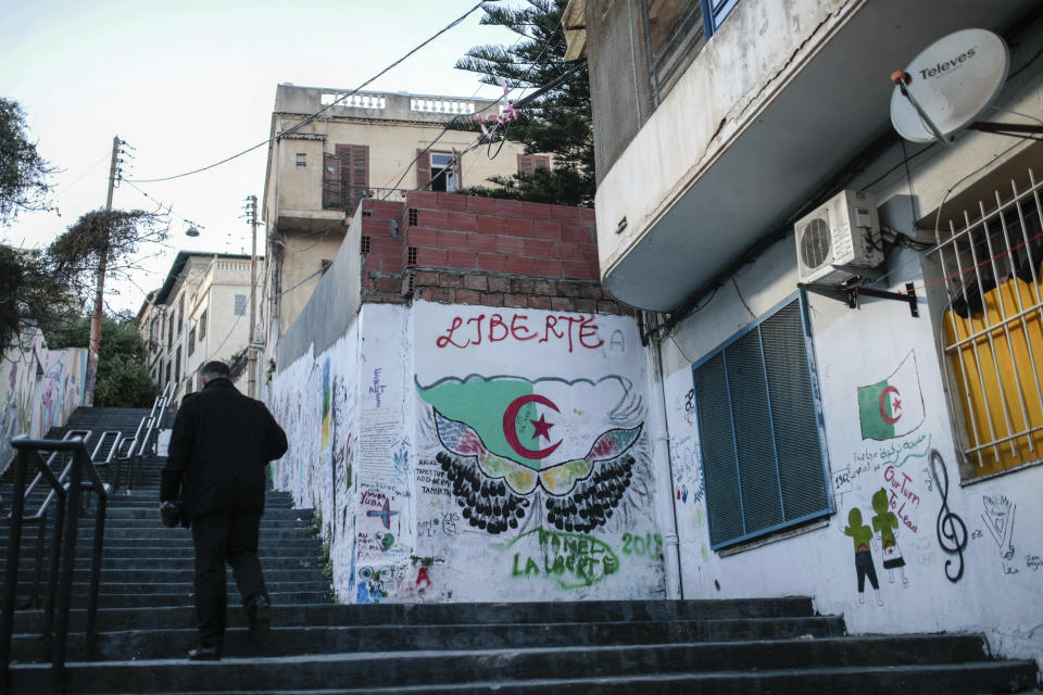 A man walks past street art that reads "liberty," supporting the current protest that has forced out longtime President Abdelaziz Bouteflika, in downtown Algiers, Algeria, Monday, April 8, 2019. The pro-democracy movement has forced out Bouteflika and demanded that other top figures leave too. (AP Photo/Mosa'ab Elshamy)