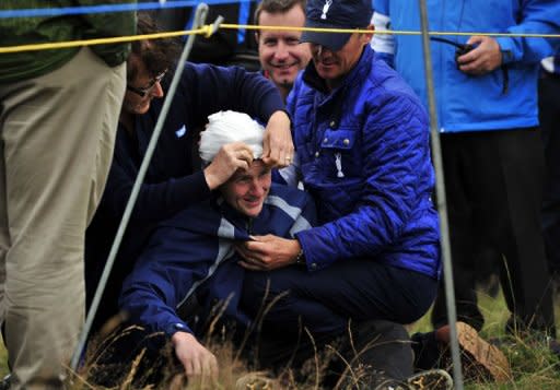 16 year old spectator, Jason Blue is helped after being struck on the head by a ball hit by Rory McIlroy of Northern Ireland on the 15th hole during his first round on the opening day of the 2012 Open Championship at Royal Lytham and St Annes in Lytham