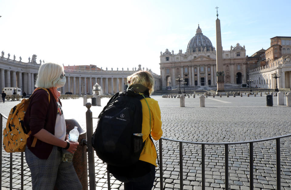 People stand behind barriers on Tuesday after the Vatican's Saint Peter's Square and its main basilica were closed to tourists as part of control measures against the spread of COVID-19. (Photo: Elisabetta A. Villa via Getty Images)