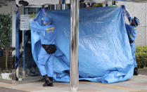 <p>Police investigators cover the entrance of the Tsukui Yamayuri-en, a facility for the disabled where a number of people were killed and dozens injured in a knife attack, with a blue sheet in Sagamihara, outside Tokyo Tuesday, July 26, 2016. (AP Photo/Eugene Hoshiko)</p>