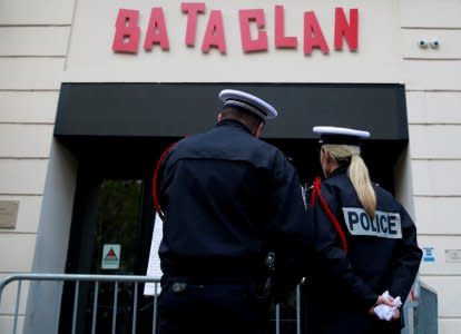 Police stand in front of commemorative plaque at the entrance of the Bataclan concert venue after a ceremony marking the third anniversary of the Paris attacks of November 2015 in which 130 people were killed, in Paris, France, November 13, 2018. REUTERS/Gonzalo Fuentes