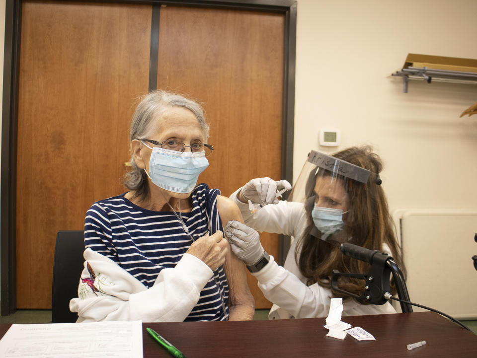 Nola Lemaster receives a COVID-19 vaccine administered by registered nurse Krista Alexander, of the Greenup County Health Department, at the Greenup County Health Department on Tuesday, Jan. 12, 2021, in Greenup, Ky. Lemaster received his vaccine as part of the rollout of Phase 1B for those age 70 and older in the state. (Matt Jones/The Daily Independent via AP)