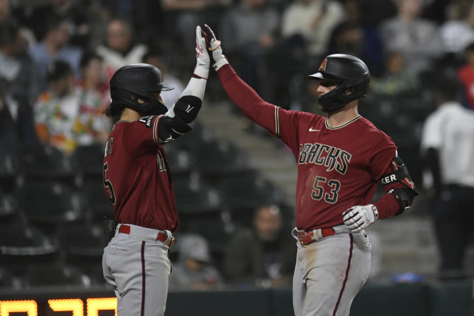 Arizona Diamondbacks' Christian Walker (53) celebrates with teammate Alek Thomas at home plate after hitting a two-run home run during the sixth inning of a baseball game against the Chicago White Sox, Tuesday, Sept. 26, 2023, in Chicago. (AP Photo/Paul Beaty)