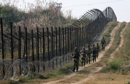 Border Security Force (BSF) soldiers patrol the fenced border with Pakistan at Babiya village in Hira Nagar sector, about 80 km (50 miles) from Jammu December 6, 2013. REUTERS/Mukesh Gupta/Files