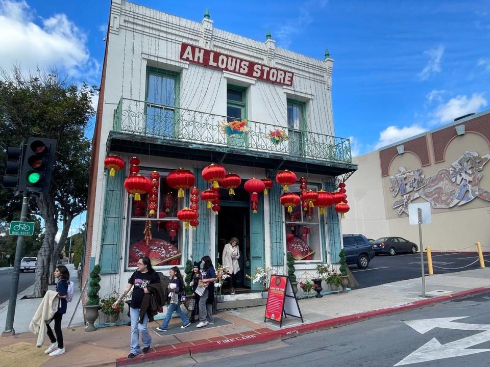 People stopped and posed for photos in front of the Ah Louis Store building in downtown San Luis Obispo. The historic business was decorated ahead of a Lunar New Year block party to be held Fe. 10, 2024