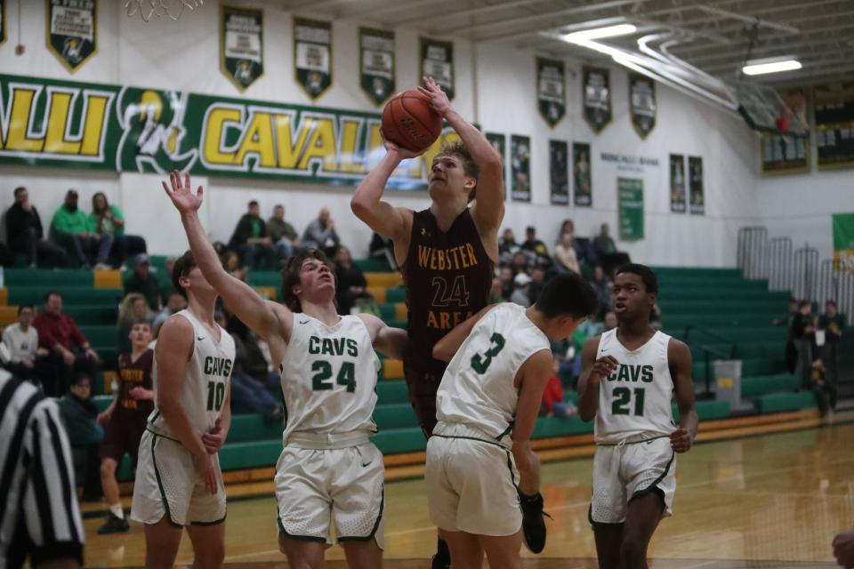 Webster Area's Jayden Keller goes for a shot over Aberdeen Roncalli's Maddox Miller (24) and Maddox May (3). Keller finished the game with 30 points.