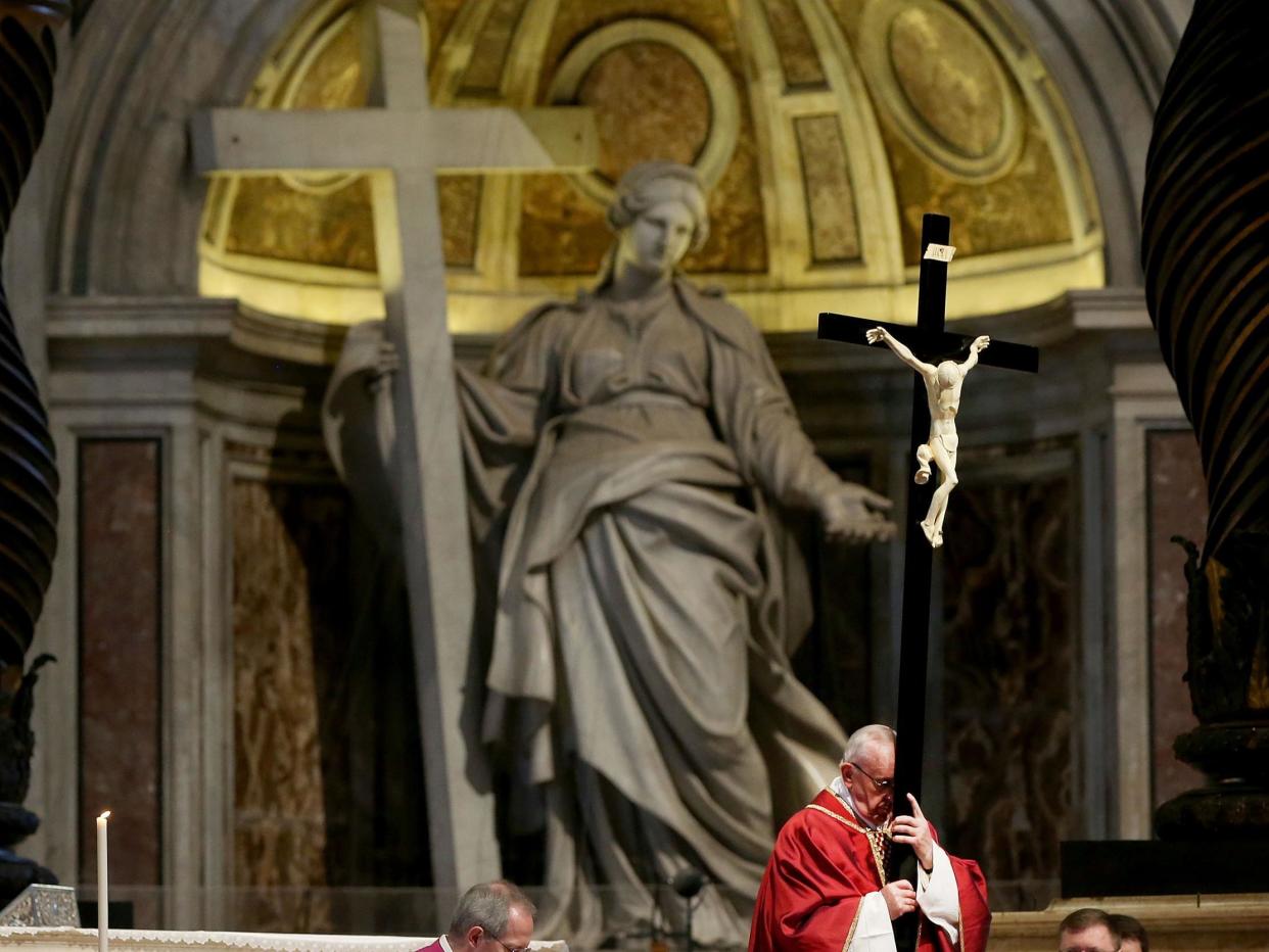 Pope Francis holds the Holy cross during the Celebration of the Lord's Passion at St. Peter's Basilica in Vatican City, Vatican on 14 April 2017: Getty Images