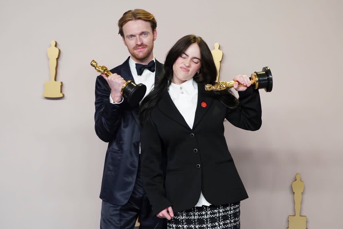 Finneas and Billie Eilish with their Oscar trophies for Best Original Song (AP)
