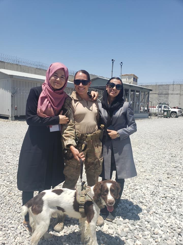 Chase and his handler Kristen St. Pierre pose during one of his rounds with some local women in Afghanistan. / Credit: Photo courtesy of Kristen St. Pierre