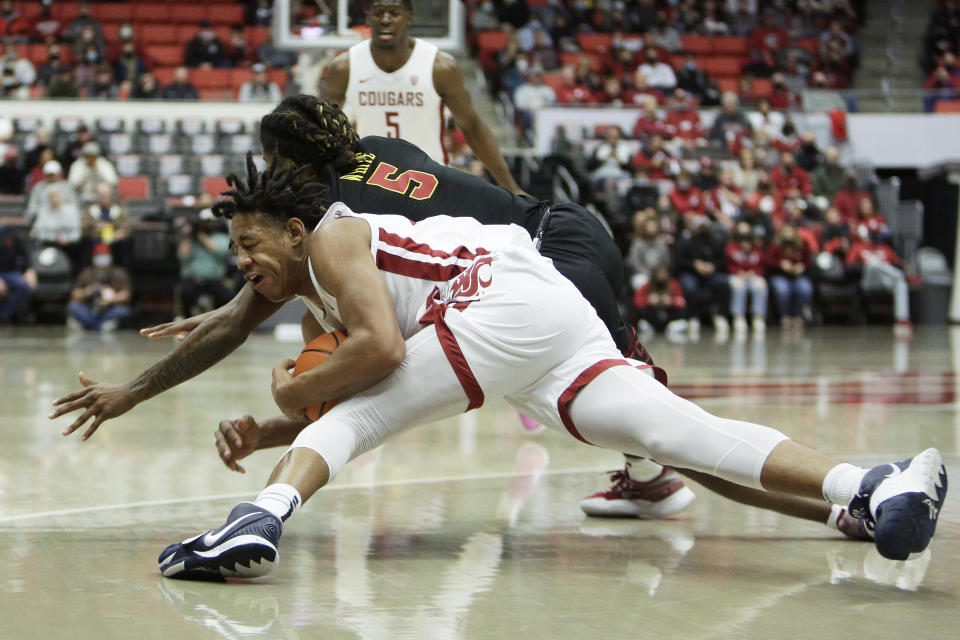 Washington State center Dishon Jackson, front, secures the ball against Southern California guard Isaiah White during the first half of an NCAA college basketball game, Saturday, Dec. 4, 2021, in Pullman, Wash. (AP Photo/Young Kwak)