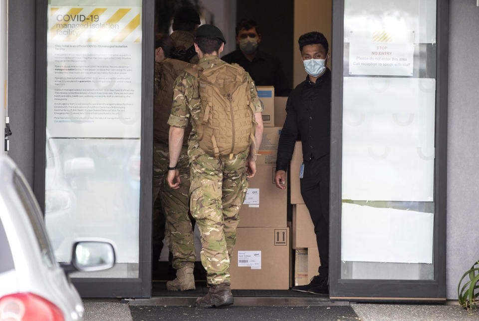 Military personnel enter the Sudima Hotel in Christchurch, New Zealand, Tuesday, Oct. 20, 2020. A number of fishing crew who flew into New Zealand on chartered planes have the coronavirus. The crew members have been in quarantine at the Christchurch hotel since they arrived, and tested positive during routine testing, officials said. The news could deal a blow to New Zealand’s efforts to restart its fishing industry, which has struggled to find local workers to crew fishing vessels. (AP Photo/Mark Baker)