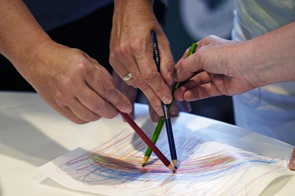 Teachers trace the lead line while sketching during a sensory motor therapy exercise at a workshop helping teachers find a balance in their curriculum while coping with stress and burnout in the classroom, Tuesday, Aug. 2, 2022, in Concord, N.H. School districts around the country are starting to invest in programs aimed at address the mental health of teachers. Faced with a shortage of educators and widespread discontentment with the job, districts are hiring more therapist, holding trainings on self-care and setting up system to better respond to a teacher encountering anxiety and stress. (AP Photo/Charles Krupa)