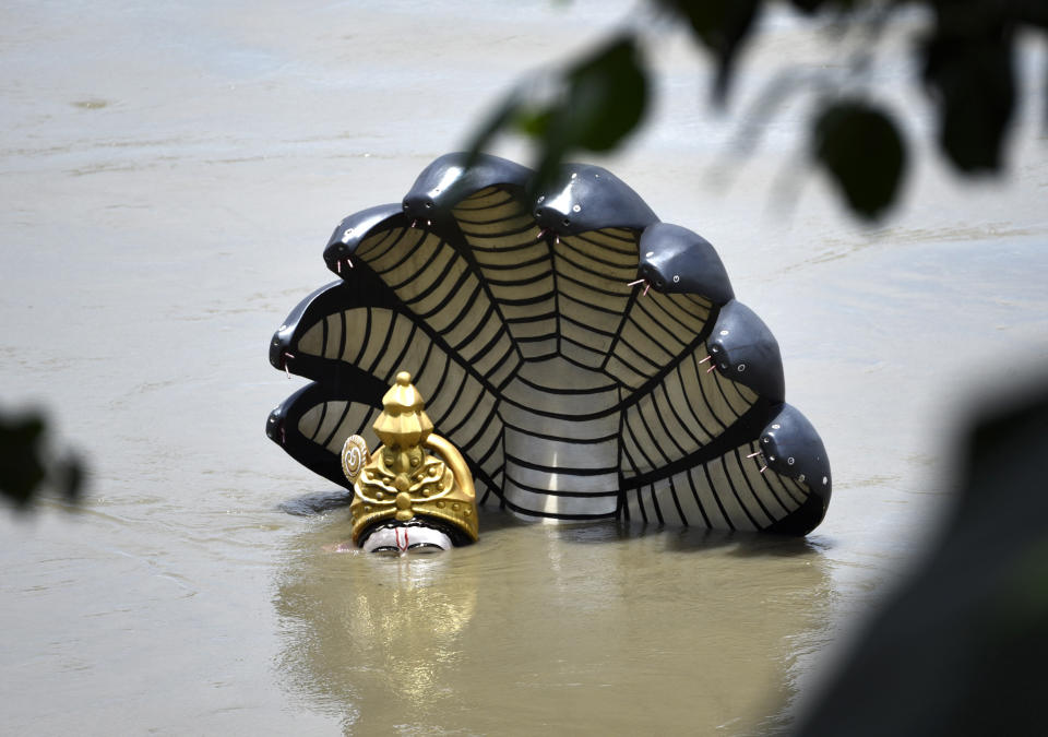 A statue of Lord Vishnu is seen submerged in the swollen Brahmaputra river, following heavy monsoon rain, at Kalipur area near Guwahati, Assam, India on July 15, 2020. (Photo by David Talukdar/NurPhoto via Getty Images)