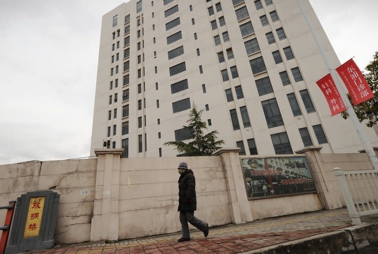 A person walks past a 12-storey building alleged in a report on February 19, 2013 by the Internet security firm Mandiant to be the home of a Chinese military-led hacking group, after the firm reportedly traced a host of cyberattacks to the building in Shanghai's northern suburb of Gaoqiao