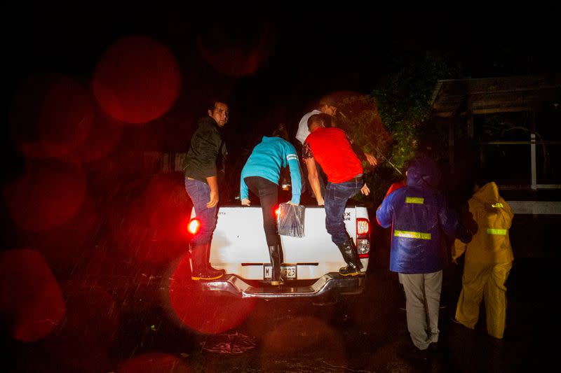 Personas suben a una camioneta para ser transportadas a una zona segura mientras el huracán Julia golpeaba las costas con viento y lluvia, en Bluefields,