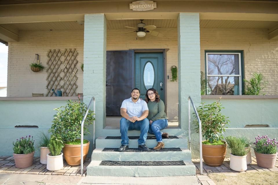 As seen on HGTV’s Home Town Kickstart with hosts Lyndsay Lamb and Leslie Davis, Chris and Mishayla Garrett pose for a portrait outside of their renovated house in Winslow, AZ.