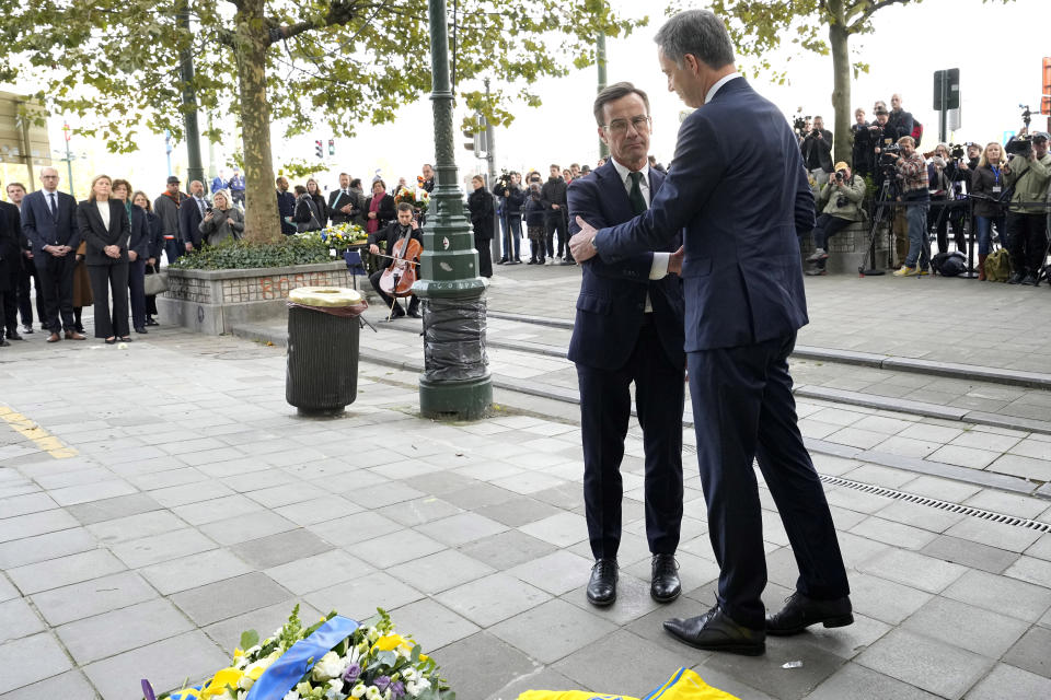 Sweden's Prime Minister Ulf Kristersson, left, and Belgium's Prime Minister Alexander De Croo shake hands after placing a floral tribute during a commemoration for the victims of a shooting in the center of Brussels, Wednesday, Oct. 18, 2023. Police in Belgium on Tuesday shot dead a suspected Tunisian extremist accused of killing two Swedish soccer fans in a brazen attack on a Brussels street. (AP Photo/Martin Meissner)