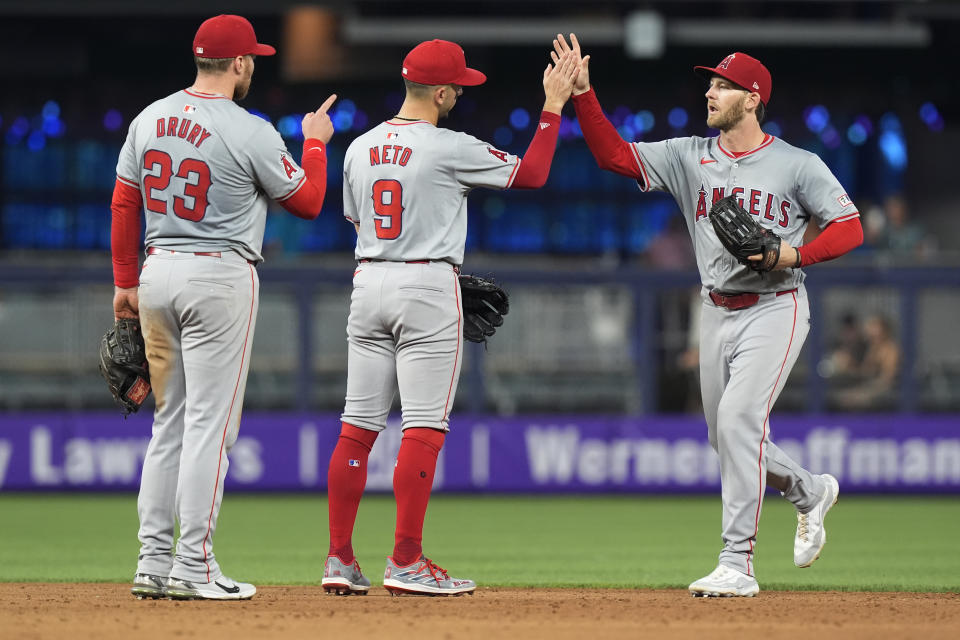 Los Angeles Angels left fielder Taylor Ward, shortstop Zach Neto (9) and second baseman Brandon Drury (23) celebrate at the end of a baseball game against the Miami Marlins, Wednesday, April 3, 2024, in Miami. The Angels defeated the Marlins 10-2. (AP Photo/Marta Lavandier)