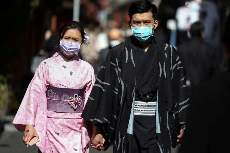 Tourists wearing kimono and protective masks visit Sensoji Temple in Tokyo