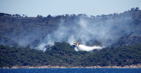 A Canadair firefighting plane drops water to extinguish a forest fire on La Croix-Valmer from Cavalaire-sur-Mer, near Saint-Tropez, France, July 25, 2017. REUTERS/Jean-Paul Pelissier