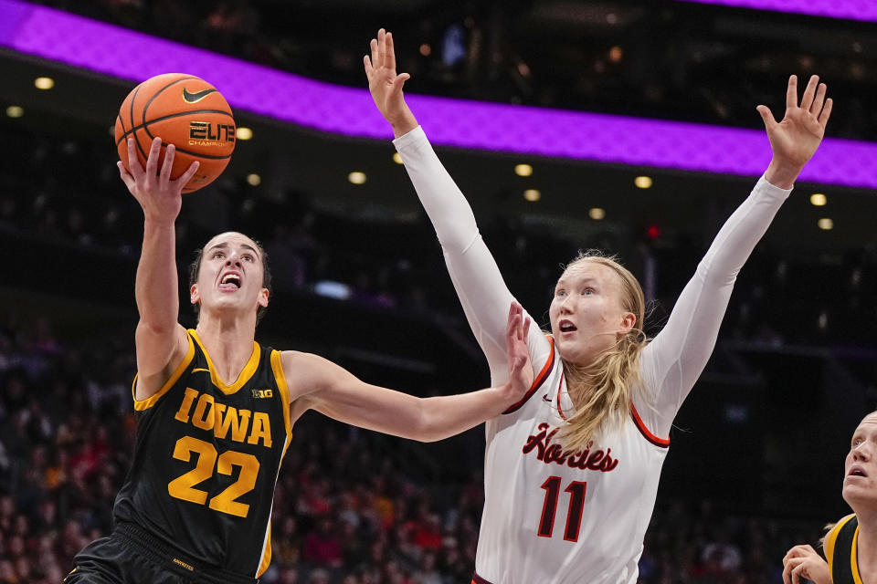 Iowa guard Caitlin Clark (22) shoots around Virginia Tech guard Matilda Ekh (11) during the first half of an NCAA women's college basketball game Thursday, Nov. 9, 2023, in Charlotte, N.C. (AP Photo/Chris Carlson)