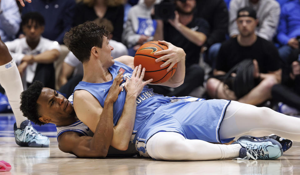 North Carolina's Cormac Ryan, right, and Duke's Jeremy Roach, left, battle for a loose ball during the first half of an NCAA college basketball game in Durham, N.C., Saturday, March 9, 2024. (AP Photo/Ben McKeown)