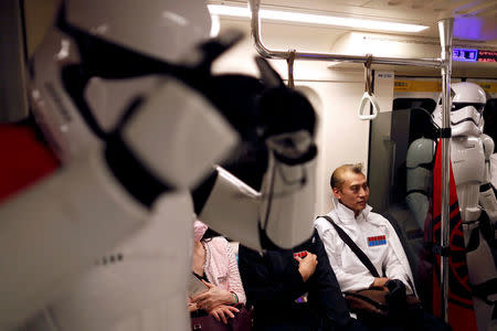 Fans dressed as Storm Trooper from "Star Wars" react at the Taipei Metro (MRT) during Star Wars Day in Taipei, Taiwan May 4, 2017. REUTERS/Tyrone Siu