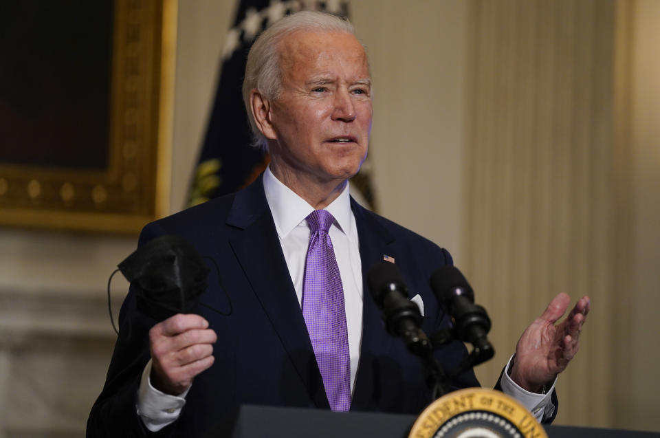 In this Jan. 26, 2021, photo, President Joe Biden holds his face mask as he speaks on COVID-19, in the State Dining Room of the White House in Washington. Biden is dispatching the nation’s top scientists and public health experts to regularly brief the American public about the pandemic. Beginning Jan. 27, the experts will host briefings three times a week on the state of the outbreak and efforts to control it. (AP Photo/Evan Vucci)