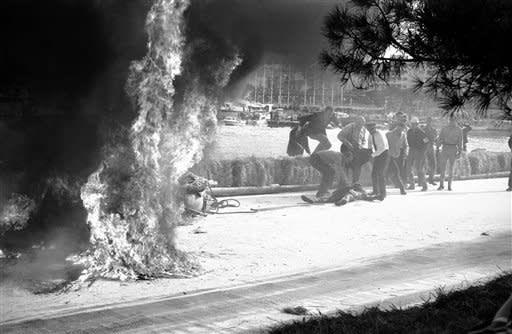 Italian race driver Lorenzo Bandini sprawls on a ground after being pulled from his flaming Ferrari during Grand Prix Race in Monaco May 7, 1967. He was taken a hospital. His car hit straw bales on 82nd lap, flipped over, and burst into flames. He has burns over 65 per cent of his body. (AP Photo)