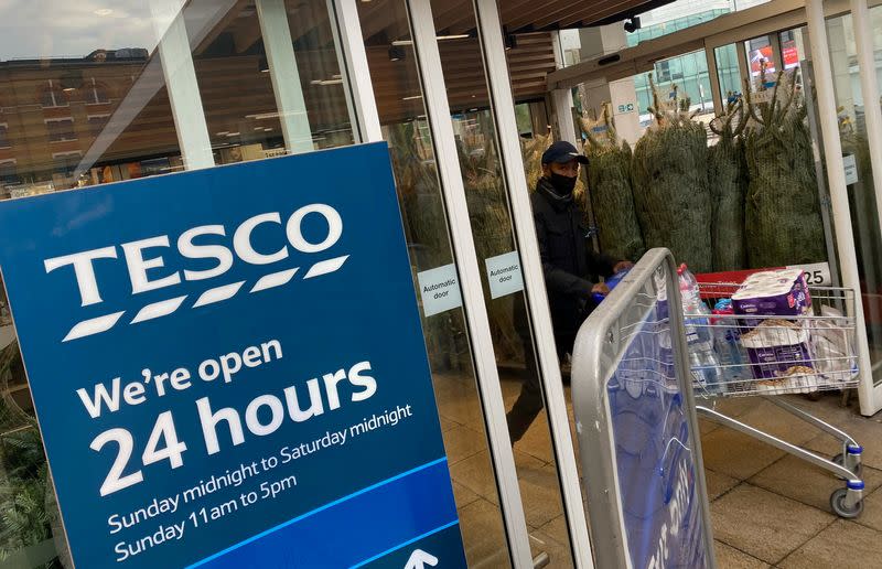 FILE PHOTO: A shopper passes christmas trees for sale at Tesco supermarket amid the spread of the coronavirus disease (COVID-19), London, Britain