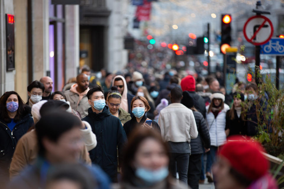 Shoppers wearing facemasks as a preventive measure against the spread of covid-19 walk along Regent Street, London. The UK recorded 37,681 Covid cases and 51 deaths on Sunday, according to the latest daily figures. A third case of the Omicron coronavirus variant has been detected in the UK, the Health Security Agency has said. (Photo by Pietro Recchia / SOPA Images/Sipa USA)