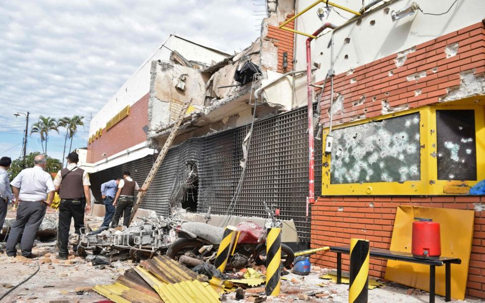 Policemen inspect the premises of multinational company Prosegur  - Credit: GUSTAVO GALEANO/AFP