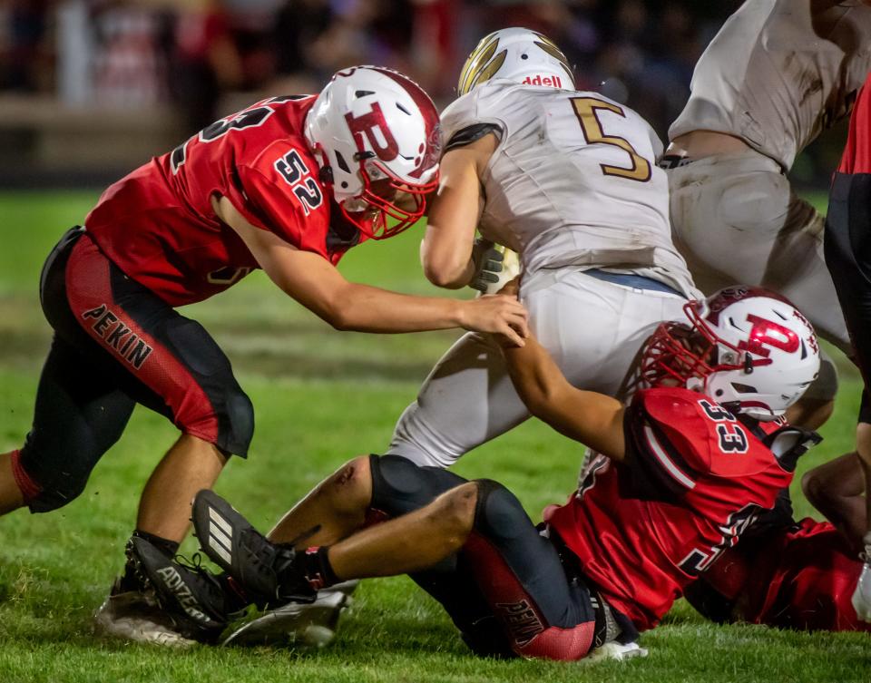 Pekin's Brayden Hoover (52) and Mason Vicary (33) bring down Dunlap ball carrier Brayden Orr in the second half Friday, Sept. 10, 2021 in Pekin. The Dragons defeated the Eagles 27-7.