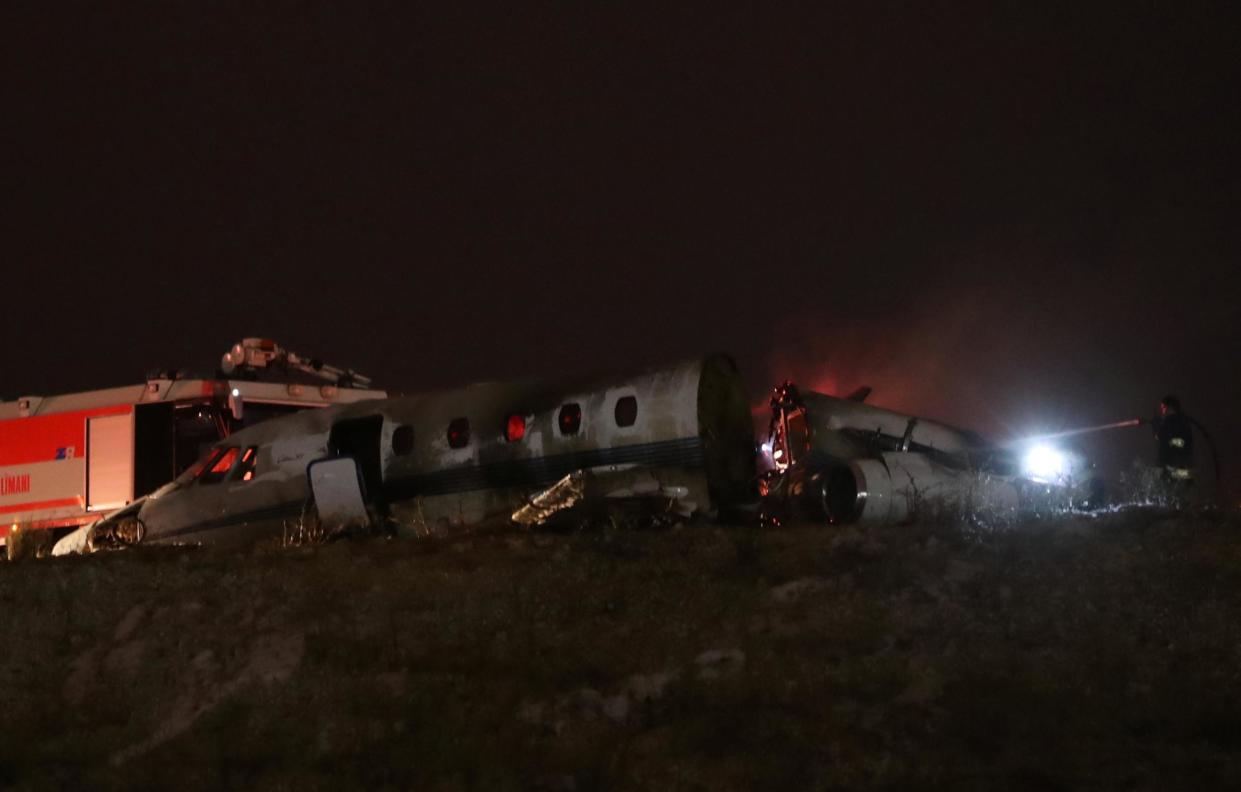 Firefigters stand next to the wreckage of a private jet after it crashed at Ataturk airport in Istanbul,: REUTERS