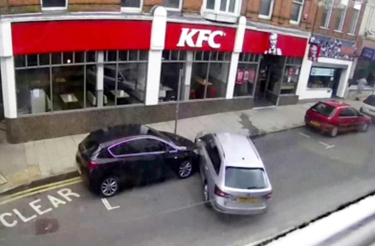 A nightmare parker smashed into two cars whilst trying to parallel park outside a KFC, all caught on video.  See SWNS story SWNNpark.  It was only a few weeks since Lisa Berry's car was repainted and fitted with a new bumper after it was hit whilst parked in the same place on Margate High Street in Kent.  The video captures the motorist's disastrous attempts as the Skoda bashes into two cars outside the fast food restaurant.  The driver of the silver estate tries to parallel park between two other cars, but instead mounts the kerb then shunts into the car in front before reversing into Lisa's car behind.  After finally getting into the spot, the driver decides it's time to go and drives off without leaving their details.  Miss Berry, who owns the stricken black Vauxhall Astra that was left scratched and dented after the parking fail, said it was the third time her car had been hit while parked near her home. 